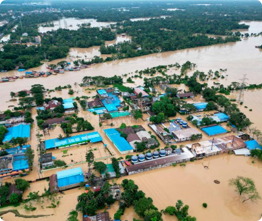 A rescue team in an orange boat navigates a flooded street in Noakhali, assisting flood-affected individuals